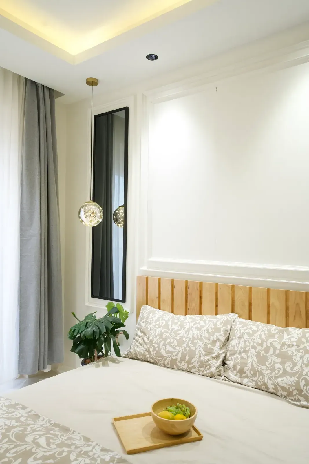 Bedroom with oak-panelled headboard and pendant lights — The Aakar